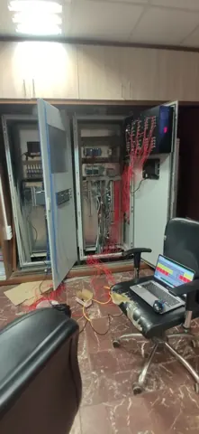 Control-room view with open equipment cabinets and an operator workstation.