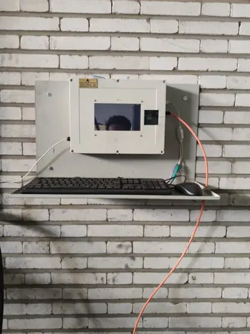 Wall-mounted QR terminal with external cabling.